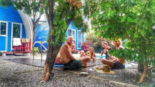 a group of people sitting on the ground under trees at Airport A4 Transit Hub - Eco Chalets in Katunayake