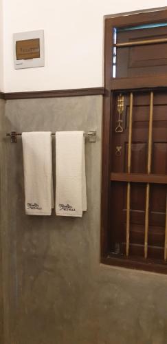 two towels are hanging on a wall in a bathroom at Ahangama Eco Villa in Ahangama