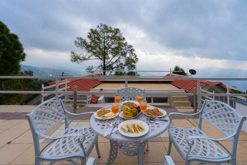 a table with plates of food on top of a balcony at StayVista at The Haven in Kasauli