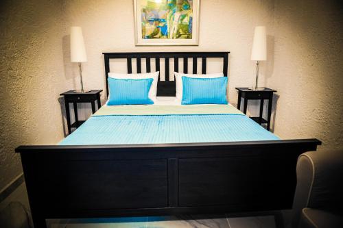 a bedroom with a large bed with blue sheets and blue pillows at Valentino Hotel in Kremasti