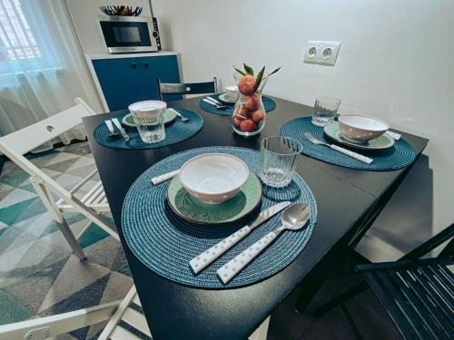 a dining room table with plates and silverware on it at Apartment One Brasov in Braşov