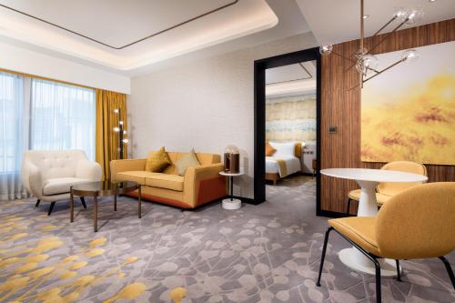 a hotel lobby with a couch and chairs and a bed at Maison L'OCCITANE in Macau