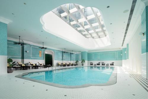 a large swimming pool in a building with a skylight at Maison L'OCCITANE in Macau