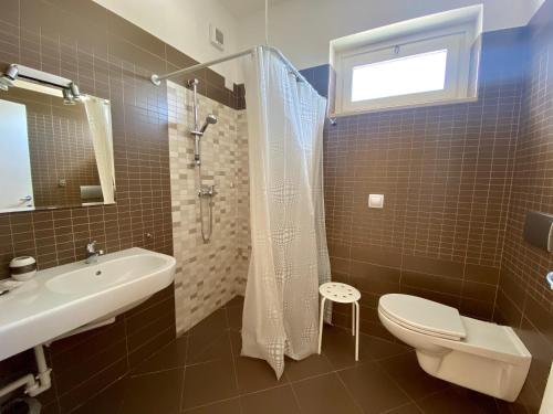 a bathroom with a sink and a toilet and a shower at Loggia Dei Lezzi in Noci