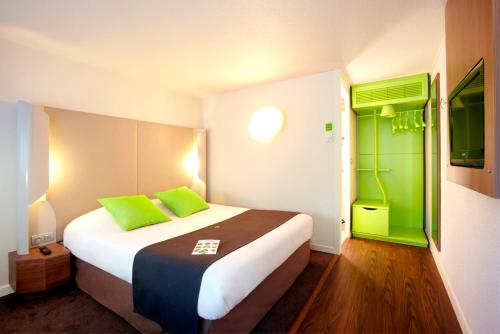 um quarto com uma cama grande com toques de verde em Campanile Bordeaux Nord - Le Lac em Bordeaux