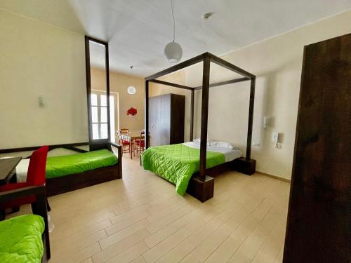a bedroom with a green bed and a large mirror at Loggia Dei Lezzi in Noci