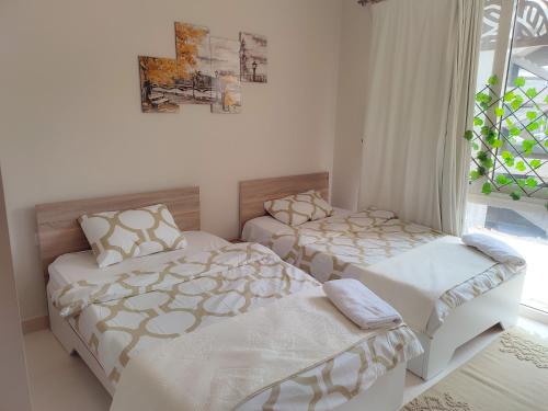 1 dormitorio con 2 camas y ventana en JOYNANT #Mangroovy 2Bedroom Pool View- Free Beach Access #GOUNA, en Hurghada