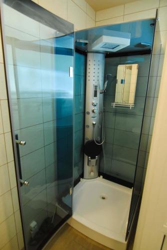 a shower in a bathroom with a glass door at Kotedžas prie jūros in Palanga
