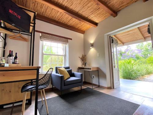 a living room with a couch and a chair at Swellendam Country Lodge - Guest House - B&B in Swellendam
