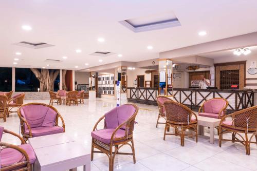 a waiting room with purple chairs and tables at Armas Green Fugla Beach in Avsallar