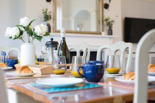 a dining room table with a bottle of wine and glasses at The Old Coastguard House in Worthing