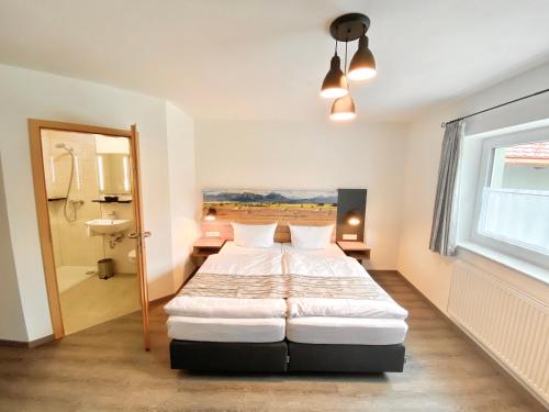 a bedroom with a bed and a bathroom with a window at Traditions-Gasthaus Bayrischer Hof in Leutkirch im Allgäu