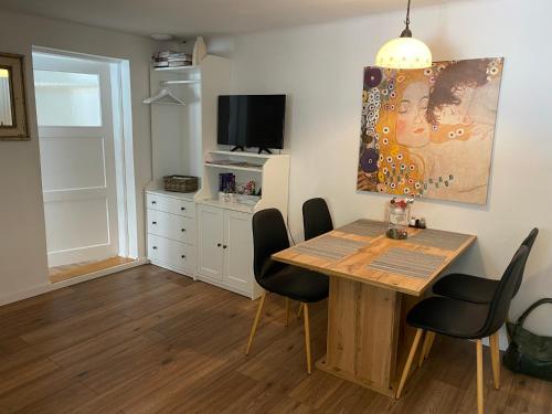 uma sala de jantar com mesa e cadeiras em Das Almsternderl - gemütliche Wohnung in Gosau em Gosau