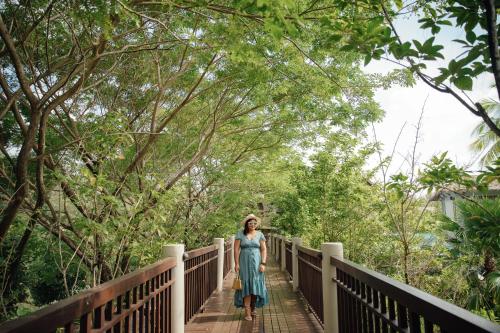 a woman in a dress walking on a bridge at The Haven Khao Lak in Khao Lak