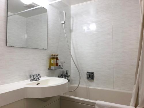 a white bathroom with a sink and a shower at Pine Shima Resort Coral Fish in Ibaruma