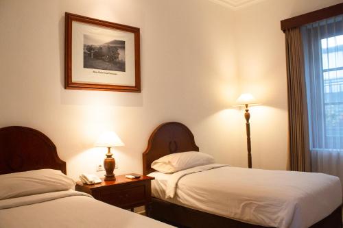 Una cama o camas en una habitación de Daroessalam Syariah Heritage Hotel