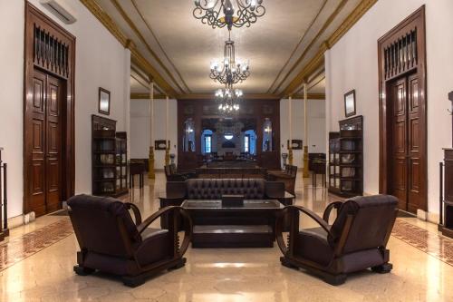 岩望的住宿－Daroessalam Syariah Heritage Hotel，客厅配有沙发、椅子和吊灯