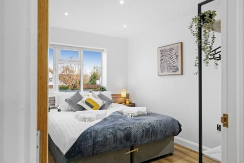 a white bedroom with a bed and a window at Modern Bungalow in Maidstone sleeps 5 with free parking in Maidstone