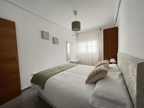 a bedroom with a large white bed with two pillows at Bellas Artes in Murcia