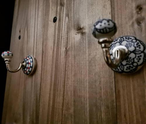 a wooden door with two knobs on it at Le monde d'Echozellia in Saint-Germain-des-Champs