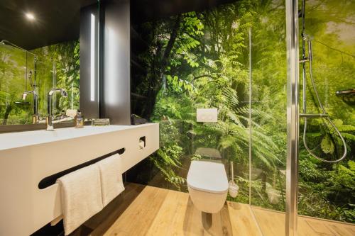 uma casa de banho com um chuveiro e um mural de floresta na parede em Rioca Stuttgart Posto 4 em Stuttgart