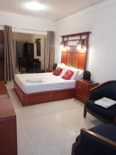 a bedroom with a bed and a couch and a chair at Posada Casa Adriana in Puerto Vallarta