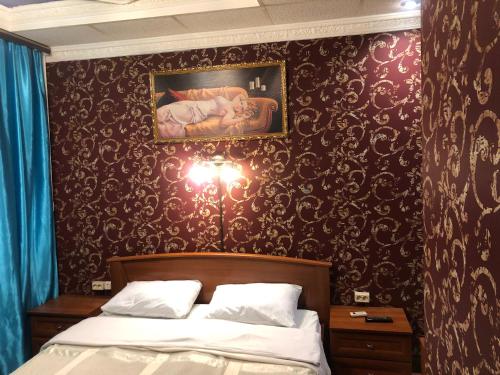 モスクワにあるУютのベッドルーム1室(ベッド1台付)が備わります。壁には絵画が飾られています。