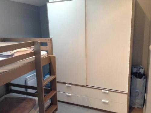 - une chambre avec des lits superposés et un placard dans l'établissement Appartement Trouville proche plage, à Trouville-sur-Mer