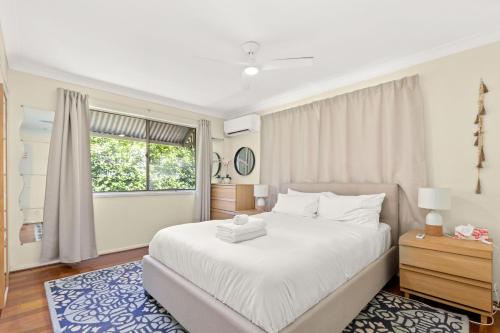 a bedroom with a large white bed and a window at KOZYGURU ALBION CHARMING HOUSE WITH 3 BEDROOM PARKING -QAL035 in Brisbane