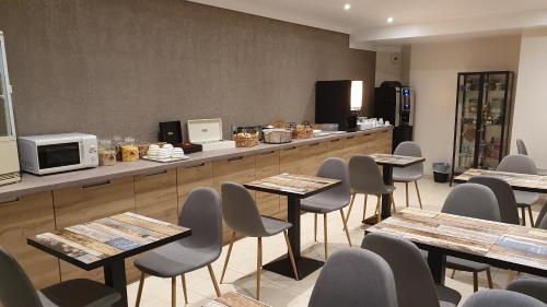 un restaurant avec des tables, des chaises et un comptoir dans l'établissement Libre Hôtel, à La Vespière
