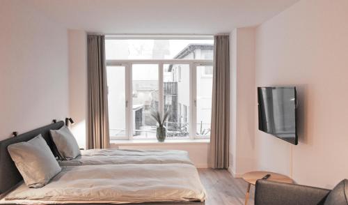 a bedroom with a bed and a large window at Nordsjællands Ferieboliger in Frederiksværk