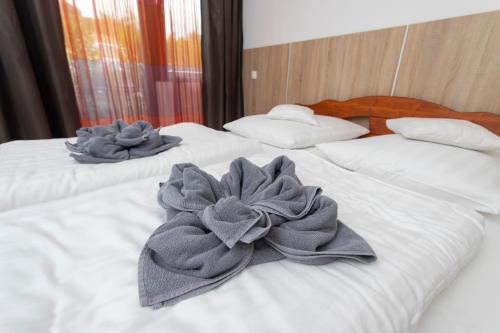 two beds with gray towels on top of them at Margaréta Apartman és Üdülőház in Bogács