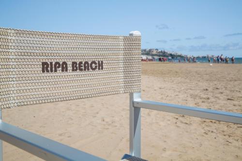 a sign on a beach with people in the background at Garden Hotel Ripa in Vieste