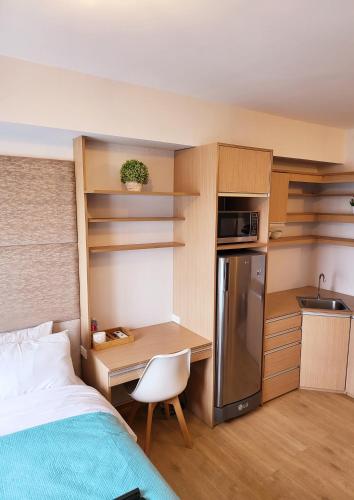 a small room with a bed and a desk and a kitchen at Steff's Condo 1805 at Centrio Tower in Cagayan de Oro
