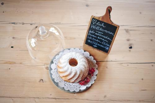 a bundt cake on a plate on a table with a sign at Omesberg-Hütt'n in Lech am Arlberg