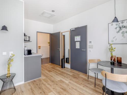 a kitchen and dining room with a table and chairs at Limehome Mönchengladbach Fliethstraße in Mönchengladbach