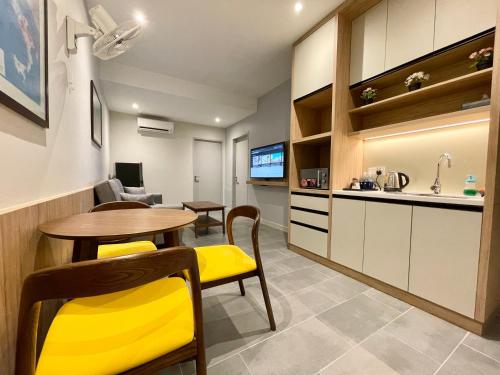 a kitchen and dining room with a table and yellow chairs at LV Modern Suite Langkawi by Zervin in Kuah