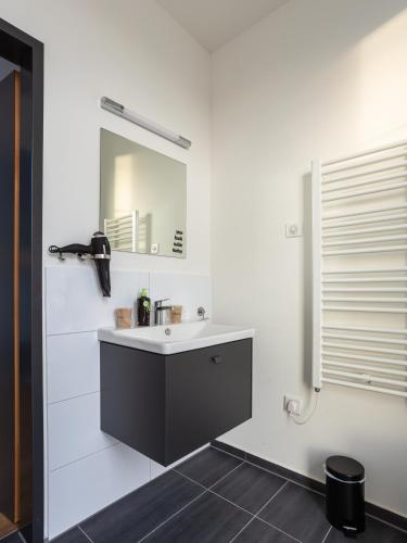 a bathroom with a sink and a mirror at Limehome Mönchengladbach Fliethstraße in Mönchengladbach