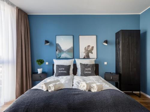 a blue bedroom with a bed with towels on it at Limehome Mönchengladbach Fliethstraße in Mönchengladbach