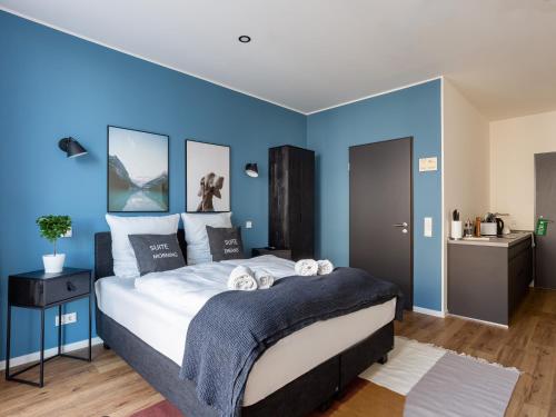a bedroom with blue walls and a large bed at Limehome Mönchengladbach Fliethstraße in Mönchengladbach