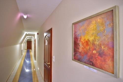 a painting hanging on a wall in a hallway at Margaréta Apartman és Üdülőház in Bogács