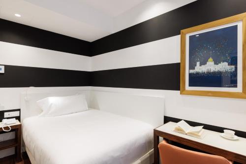 a hotel room with a bed and a desk and a picture at Hotel Morfeo in Milan