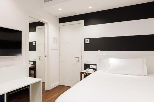 a bedroom with a white bed and a black and white wall at Hotel Morfeo in Milan