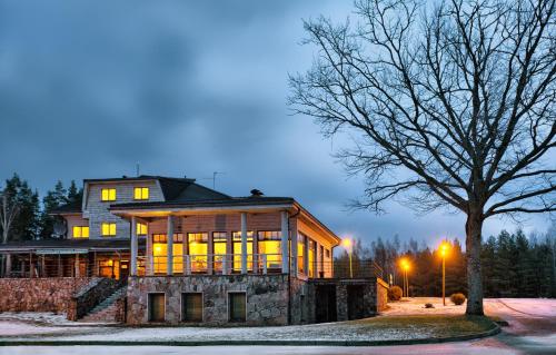 a large house with a tree in front of it at LVM tūrisma un atpūtas centrs "Ezernieki" in Meirāni