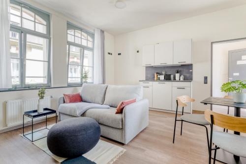 a living room with a couch and a table at Limehome Leipzig Oelßner's Hof in Leipzig