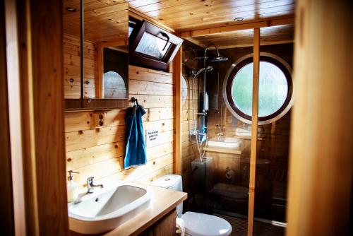 a bathroom with a sink and a toilet and a window at Houseboat Bonanza Prague in Prague