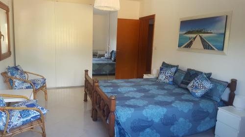 a bedroom with a blue bed and two chairs at Villa Sogno sulla Spiaggia in Fontane Bianche