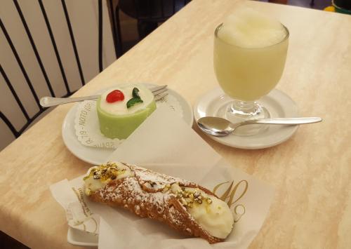 a table with two plates of food and a glass of milk at Villa Sogno sulla Spiaggia in Fontane Bianche