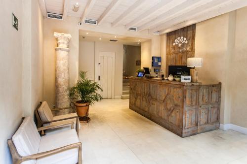 a lobby with a reception desk and chairs at Hotel Boutique Elvira Plaza in Seville