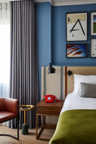 a bedroom with blue walls and a bed and a chair at Hotel Indigo Madrid - Princesa by IHG in Madrid
